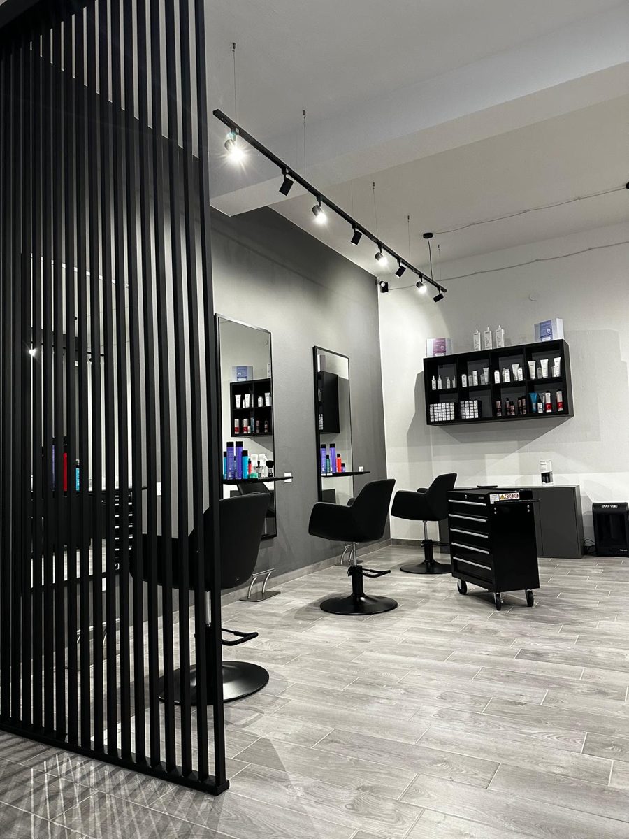 Interno del salone Bonton con postazioni, specchi e parete a listelle nere
